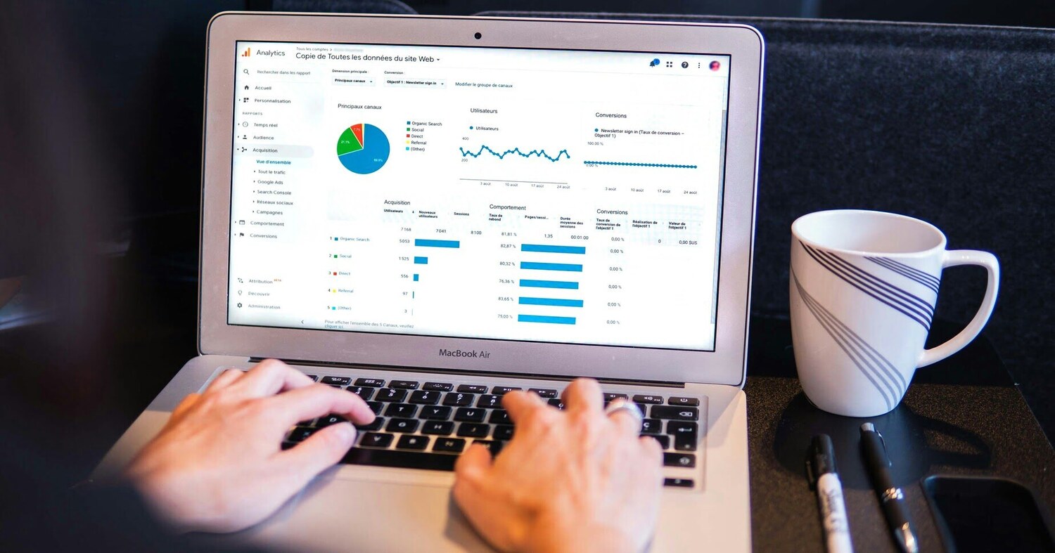 Person an Laptop mit Startseite Analytics Auswertung u.a. mit Kreisdiagramm