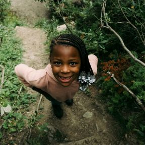 Young girl smiling in the trees.