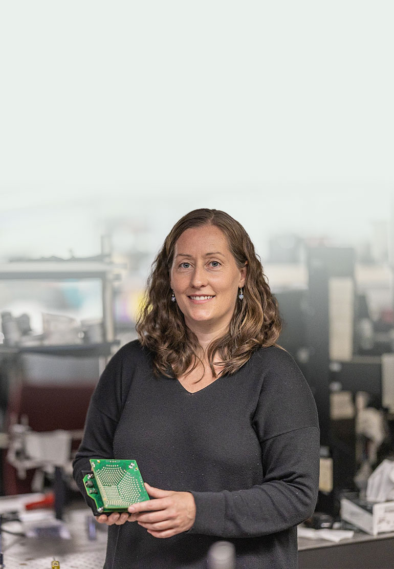 Imaging scientist Laura in a computational imaging lab holding a piece of imaging equipment