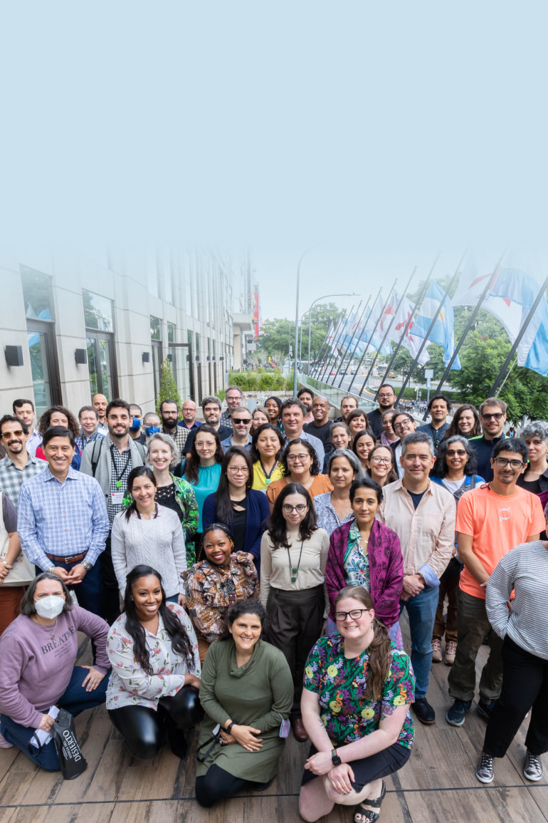 A group of fifty people gathers on a balcony outdoors.