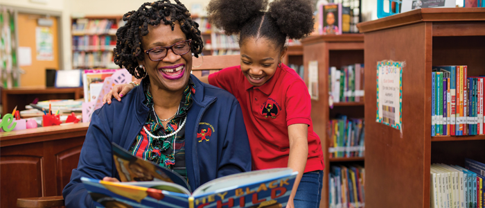 Student reading with an adult