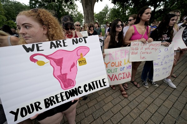 FILE - Abortion-rights advocates gather outside a the Kansas Statehouse in Topeka, Kan., to protest the U.S. Supreme Court's ruling on abortion, June 24, 2022. Kansas isn't enforcing a new law requiring abortion providers to ask patients why they want to terminate their pregnancies, as a legal challenge against that rule and other older requirements makes its way through the courts. (AP Photo/Charlie Riedel, File)