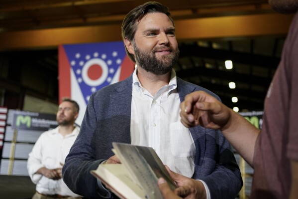 J.D. Vance, the venture capitalist and author of "Hillbilly Elegy," holds his book as he speaks with supporters after a rally on July 1, 2021, in Middletown, Ohio. (AP Photo/Jeff Dean, File)