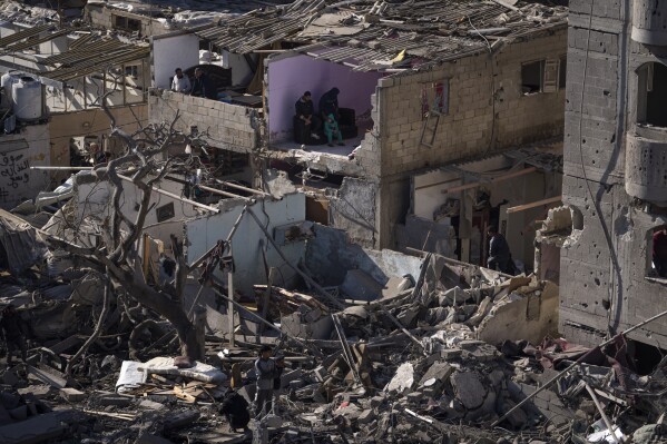 FILE - Palestinians look at the destruction after an Israeli strike on residential buildings and a mosque in Rafah, Gaza Strip, Feb. 22, 2024. Israel and Hamas appear to be seriously negotiating an end to the war in Gaza and the return of Israeli hostages. A leaked truce proposal hints at concessions by both sides following months of stalemated talks. (AP Photo/Fatima Shbair, File)