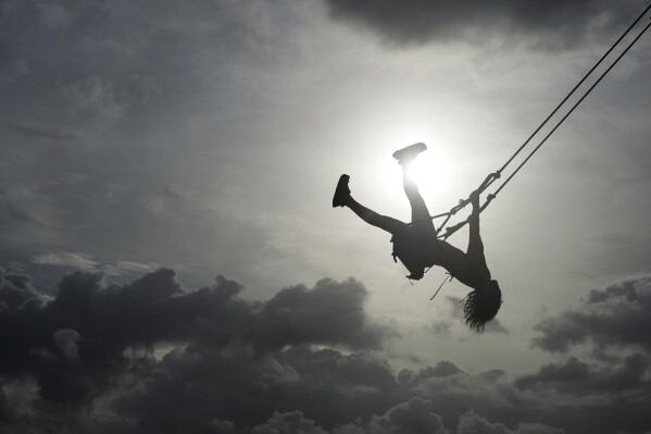 A woman swings on a swing in Venao beach in Pedasi, Panama, July 13, 2024. (AP Photo/Matias Delacroix)