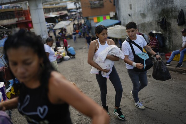 Residents walk through the Petare neighborhood of Caracas, Venezuela, Tuesday, July 16, 2024. (AP Photo/Ariana Cubillos)