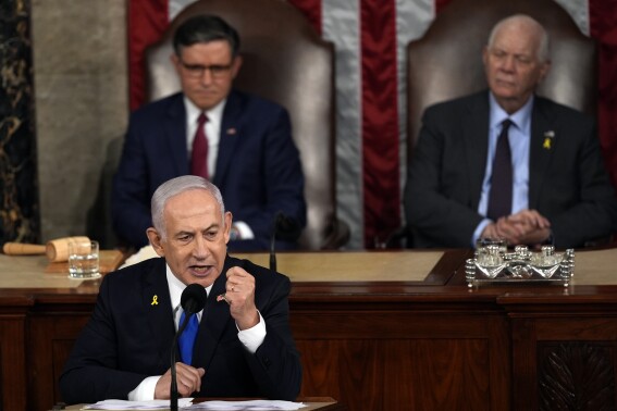 Israeli Prime Minister Benjamin Netanyahu speaks to a joint meeting of Congress at the Capitol in Washington, Wednesday, July 24, 2024, as House Speaker Mike Johnson of La., and Senate Foreign Relations Chair Ben Cardin, D-Md., listen. (AP Photo/Julia Nikhinson)