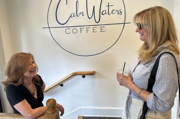 Lynn Natale, 62, right, of Newtown in Bucks County, Pa., talks to her friend Terry Sykes at a Newtown, Pa., coffee shop on June 14, 2024. Natale says she thinks Donald Trump struggles to communicate with women, but "the alternative is unacceptable," referring to Democratic President Joe Biden. (AP Photo/Thomas Beaumont)