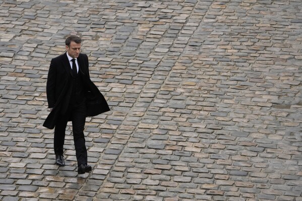 FILE - French President Emmanuel Macron walks back during a ceremony at the Invalides monument, Wednesday, Feb.7, 2024. French President Emmanuel Macron's expected political failure in decisive parliamentary elections Sunday may paralyze the country, weaken him abroad and overshadow his legacy, just as France is about to be in the global spotlight as host of the Paris Olympics. (AP Photo/Thibault Camus, File)