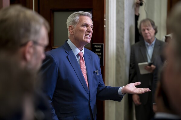 FILE - Speaker of the House Kevin McCarthy, R-Calif., talks to reporters outside his office about calls for an impeachment inquiry of President Joe Biden, at the Capitol in Washington, July 25, 2023. The White House says Congress should pass a short-term funding measure to ensure the government keeps operating after the current budget year ends Sept. 30. McCarthy, R-Calif., told Fox News on Sunday that he “would actually like” to have a short-term funding measure because a shutdown “hurts the American public.” (AP Photo/J. Scott Applewhite, File)