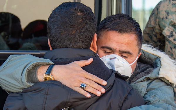 Two men hugging.