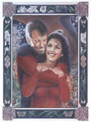 (unknown date) "Rendezvous in the Arboretum" -- artist's description: "A lovely, romantic and affectionate piece in full, rich color of Will leaning down from his lofty height to wrap up Deanna in his arms from behind in a hug. Both characters are in uniform and are smiling -- Will, a little mischievously, Deanna, with a rare open, utterly happy smile. There are flowers and other botanicals in the background; a portal serves as the backdrop, and there are more flowers in the panels of the multi-colored, intricate Celtic border." [49]