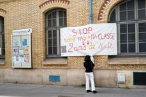 Pancarte contre la suppression de classes dans une école publique de Paris, académie qui voit 173 classes supprimées à la rentree 2024.