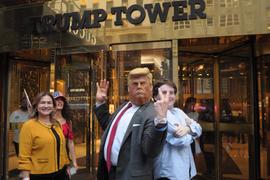 Un imitateur de Donald Trump portant un masque Trump se tient à côté d’un piéton à l’extérieur de la Trump Tower à Manhattan, à New York.