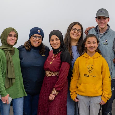 a group of high school students posing at the front of a classroom.