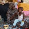 A woman feeds a child at a school used as a gathering point for displaced people in Port Sudan. (file)