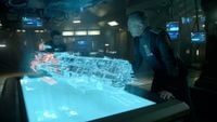 Del Rio and a subordinate viewing a holographic schematic on the bridge.