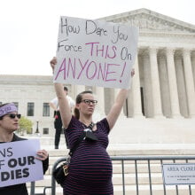 A pregnant pro-choice protestor stands in front of the Supreme Court after Roe v Wade leak