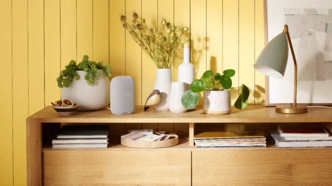 google nest smart speaker on credenza with home decor items