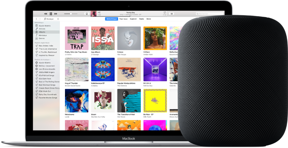 Un MacBook avec iTunes à l’écran et un HomePod à proximité.