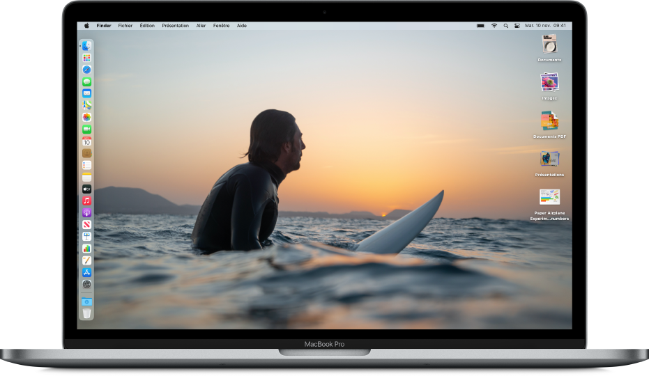 Bureau d’un Mac au mode Sombre, économiseur d’écran personnalisé, Dock placé le long du bord gauche de l’écran et piles sur le bureau le long du bord droit de l’écran.