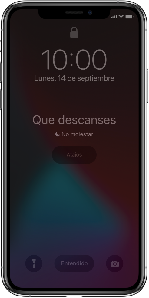 Pantalla del iPhone mostrando “Que descanses” y “No molestar activado” en el centro. Debajo se encuentra el botón Atajos. En la parte inferior de la pantalla, de izquierda a derecha, se encuentran los botones Linterna, Cerrar y Cámara.