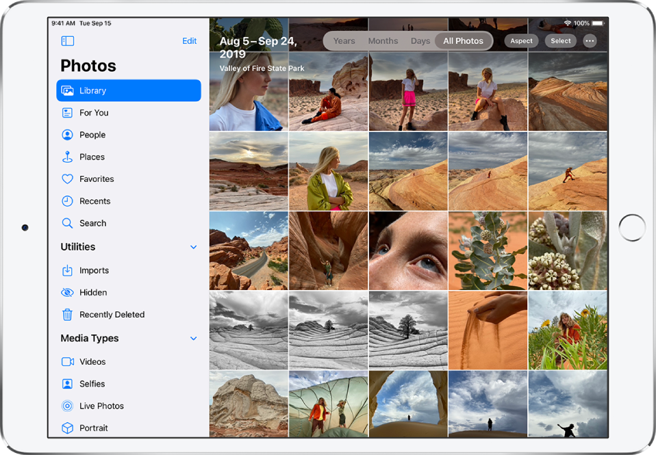 On the left side of a screen in Photos is a sidebar to select Library, For You, People, Places, and other categories; Library is selected.. The rest of the screen shows the photo library in All Photos view. At the top of the photo library is the date and location where the photos were taken. In the top center are options to view photos by Years, Months, Days, and All Photos; All Photos is selected. In the top right of the screen are the Aspect, Select, and More buttons.