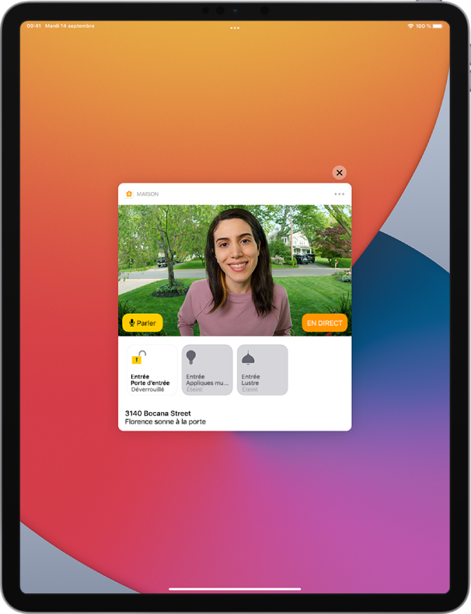 Une notification depuis Maison est activée sur l’écran de l’iPad. Elle montre la photo d’une personne à la porte d’entrée avec un bouton Parler sur la gauche. Des boutons d’accessoires pour les lumières de la porte d’entrée et de l’entrée se trouvent en dessous. L’adresse du domicile se trouve dans la partie inférieure, avec les mots « Ashley sonne à la porte d’entrée ». Le bouton Fermer s’affiche en haut à droite de la notification.