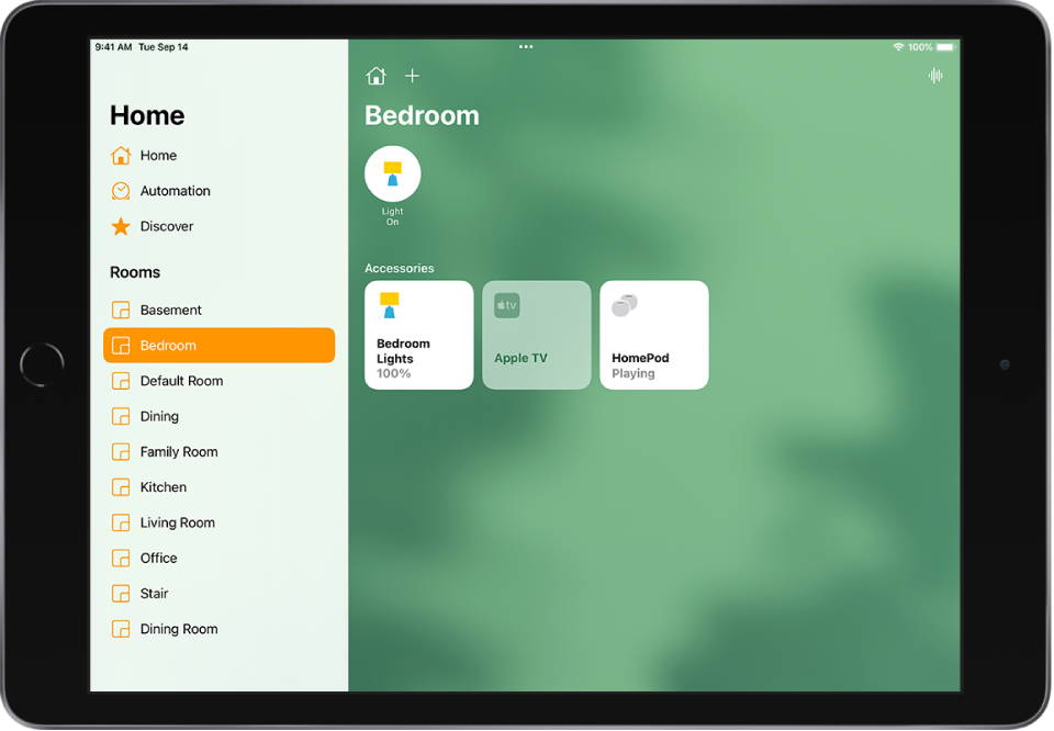 Lietotne Home ar sānu joslu kreisajā malā. Sānu joslas sadaļā Rooms ir atlasīta cilne Bedroom. Augšā pa labi no sānu joslas ir pogas Home Settings un Add. Augšējā labajā stūrī ir poga Intercom. Gaismu statusa poga augšdaļā norāda, ka gaisma ir ieslēgta. Zem tās ir piederumu pogas guļamistabas gaismām, Apple TV ierīcei un HomePod skaļrunim.
