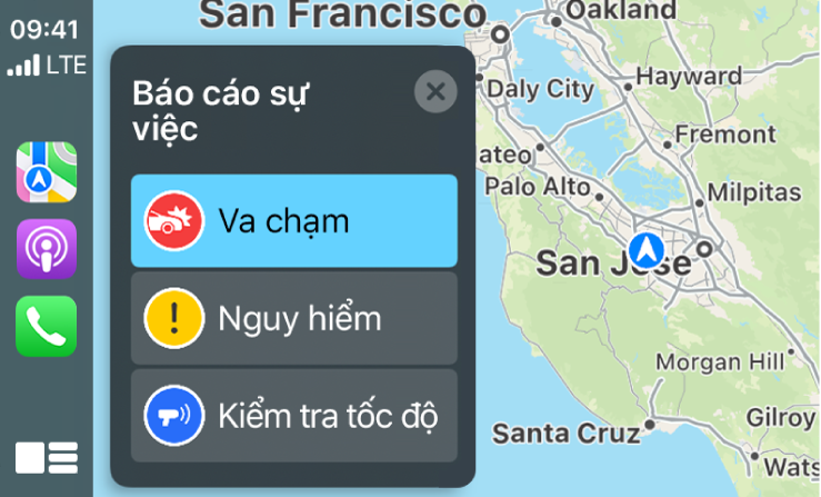 CarPlay đang hiển thị các biểu tượng cho Bản đồ, Podcast và Điện thoại ở bên trái và một bản đồ của khu vực hiện tại ở bên phải đang báo Tai nạn giao thông, Nguy hiểm hoặc Kiểm tra tốc độ.