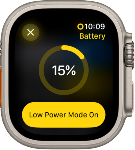 Ekrāns Low Power Mode ar daļēji dzeltenu aplis, kas atbilst atlikušās uzlādes līmenim. 15 procenti ir norādīti apļa vidū. Poga Lower Power Mode On atrodas apakšā. Augšējā kreisajā stūrī atrodas poga Close.