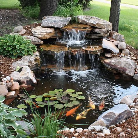 28 Stunning Koi Pond Waterfall Designs - Pond Informer Pond With Creek, River Rock Pond Backyard Waterfalls, Small Outdoor Pond With Waterfall, Backyard Waterfall Pond Ideas, Large Garden Ponds With Waterfalls, Backyard Pond Ideas Small, Koi Pond Backyard Small, Waterfall Fish Pond, Cool Pond Ideas