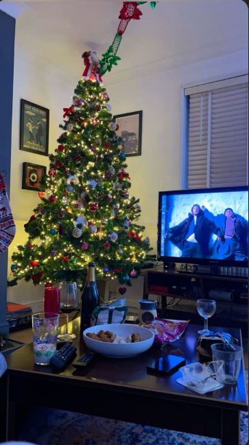 This may contain: a living room with a christmas tree and television