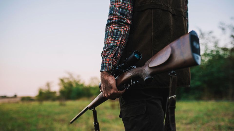 Ein Mann hält ein Gewehr in der Hand