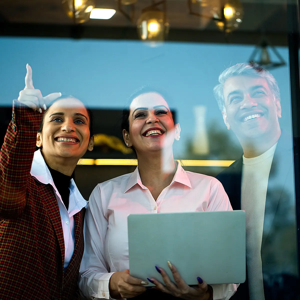 Two employees in a meeting in a glass-walled conference room