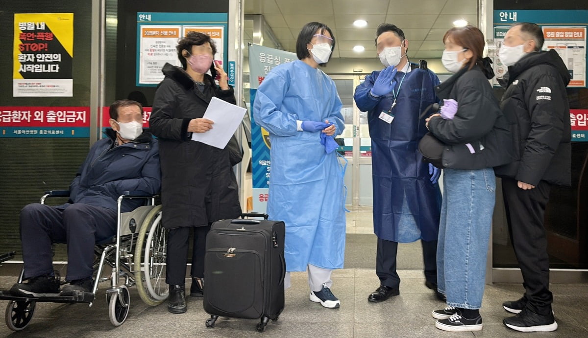 21일 서울의 한 대형병원 응급실 앞에서 의료진과 병원 관계자가 응급 환자와 가족들에게 전공의 이탈로 이용이
어렵다고 안내하고 있다./이솔 기자