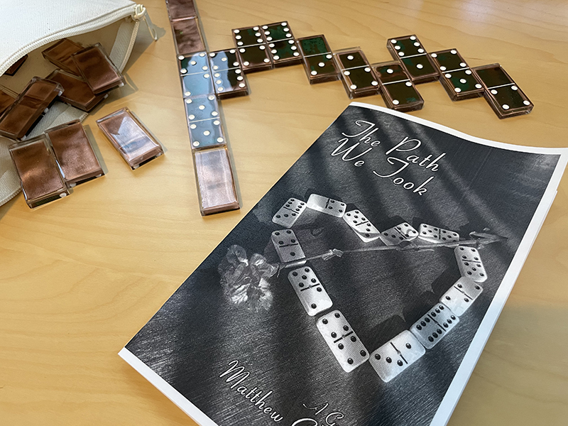 A DIY printed version of the gamebook with copper dominoes nearby. 