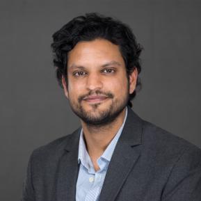 image of male wearing a grey suit with a blue shirt