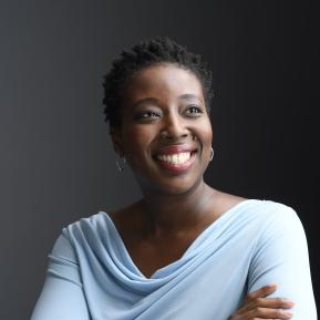 image of female wearing a light blue top smiling looking into the distance