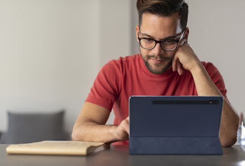 hombre con camisa roja mirando una tablet