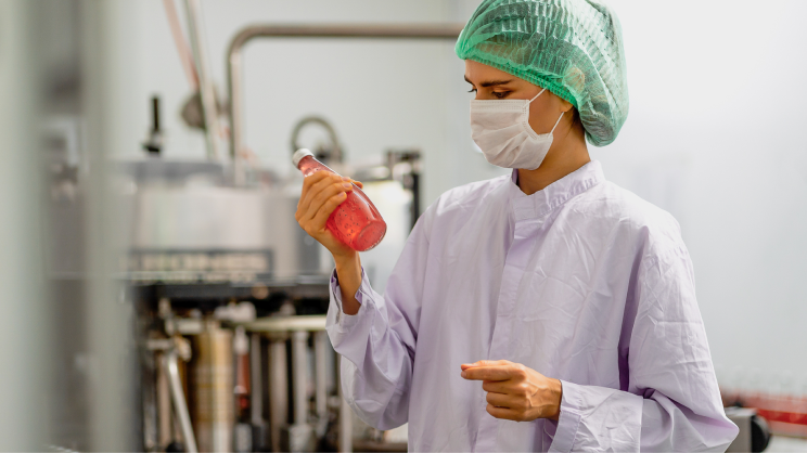 A scientist examining a glass jar 