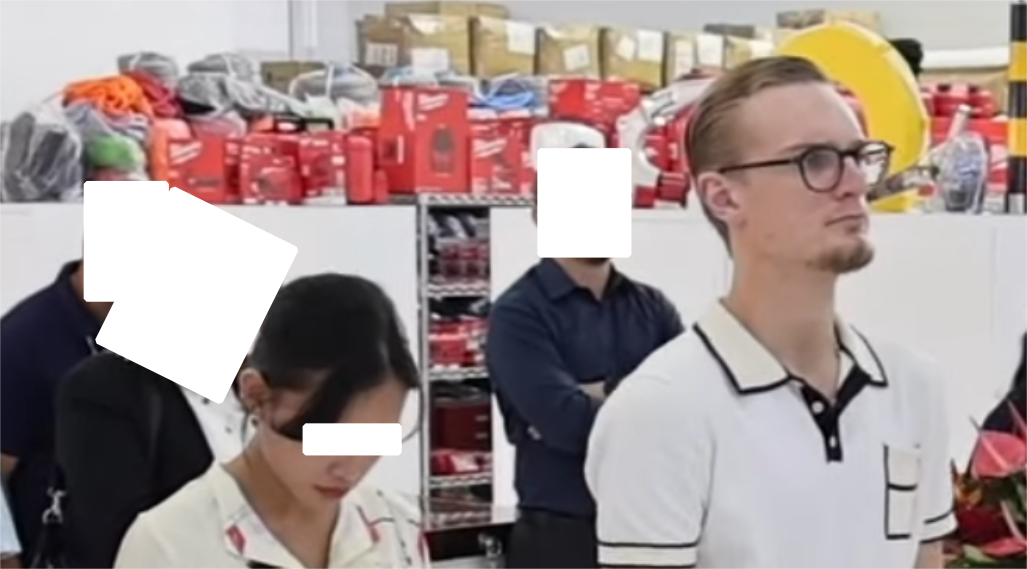 a photo of a white man with a beard and glasses (adrian dittmann) standing in a warehouse next to a southeast asian woman