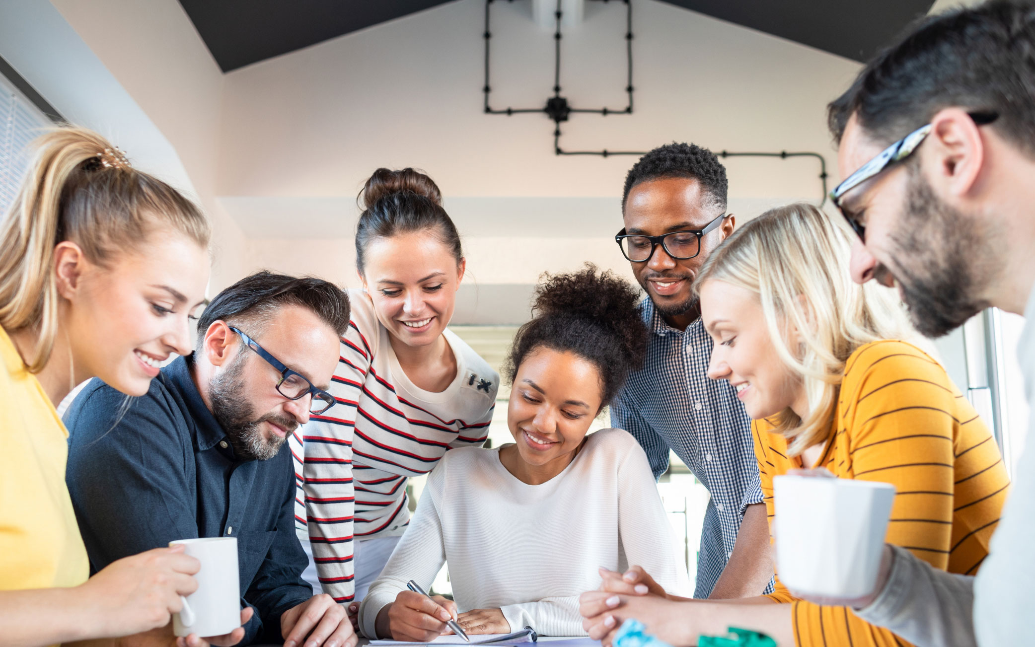 group of people looks at notebook one person is pointing at