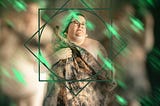 A very fat, white person looking off camera and holding a tie-dyed scarf. They are surrounded by a green set of geometric frames and the background is two photos of them naked, blurred almost beyond recognition.