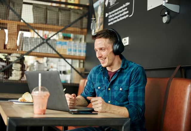 Man working on laptop from cafe