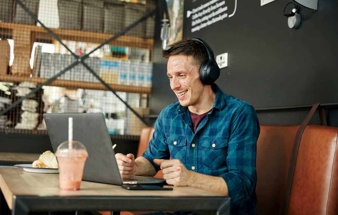 Man working on laptop from cafe