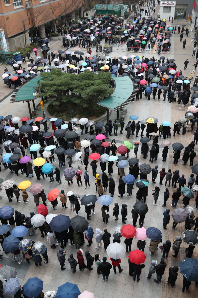 비가 내리는 28일 서울 양천구 목동 행복한백화점에서 열린 마스크 긴급 노마진 판매 행사에서 시민들이 마스크를 구매하기 위해 길게 줄을 서 있다. / 연합뉴스