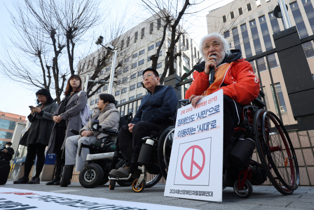 박경석 전국장애인차별철폐연대(전장연) 상임공동대표 및 관계자들이 1일 오전 서울서부지법 앞에서 이날 열린 삼각지역 스티커 부착 등 공동재물손괴 혐의 관련 공판에 출석하기 앞서 관련 기자회견을 하고 있다. 연합뉴스