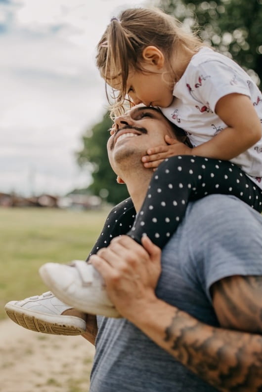 Father holding daughter on his shoulder 