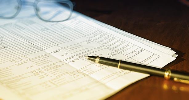 Image of pen atop stack of papers